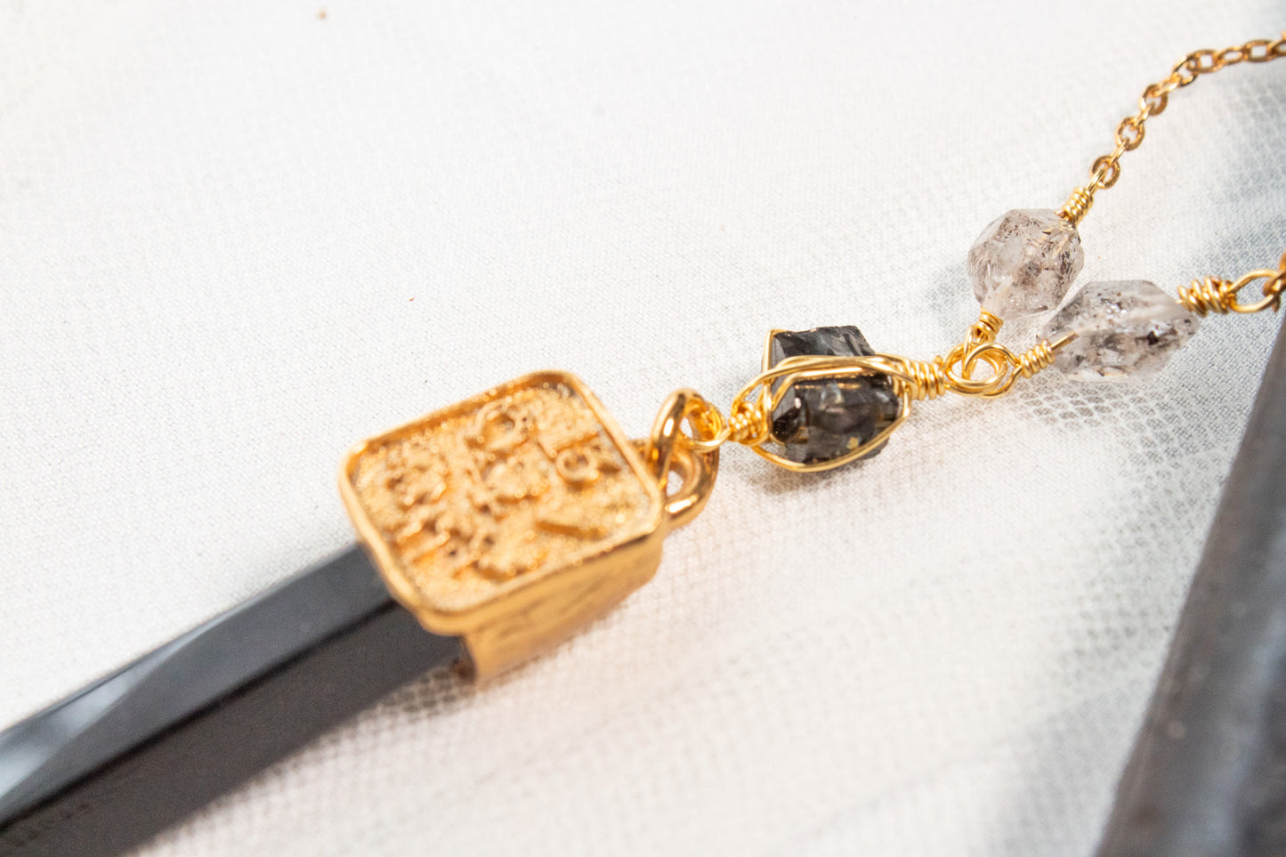 Bastión. Collar con punta de obsidiana, shungita, cuarzo herkimer y símbolos de buena fortuna