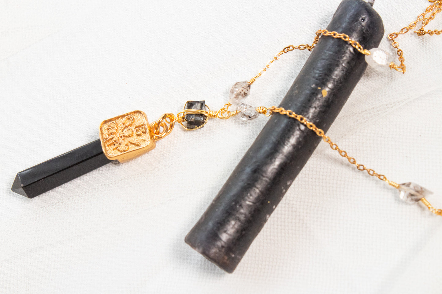 Bastión. Collar con punta de obsidiana, shungita, cuarzo herkimer y símbolos de buena fortuna
