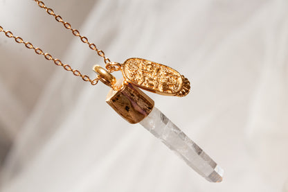 Umbría. Collar con punta de cuarzo blanco y dije oval con símbolos de buena fortuna