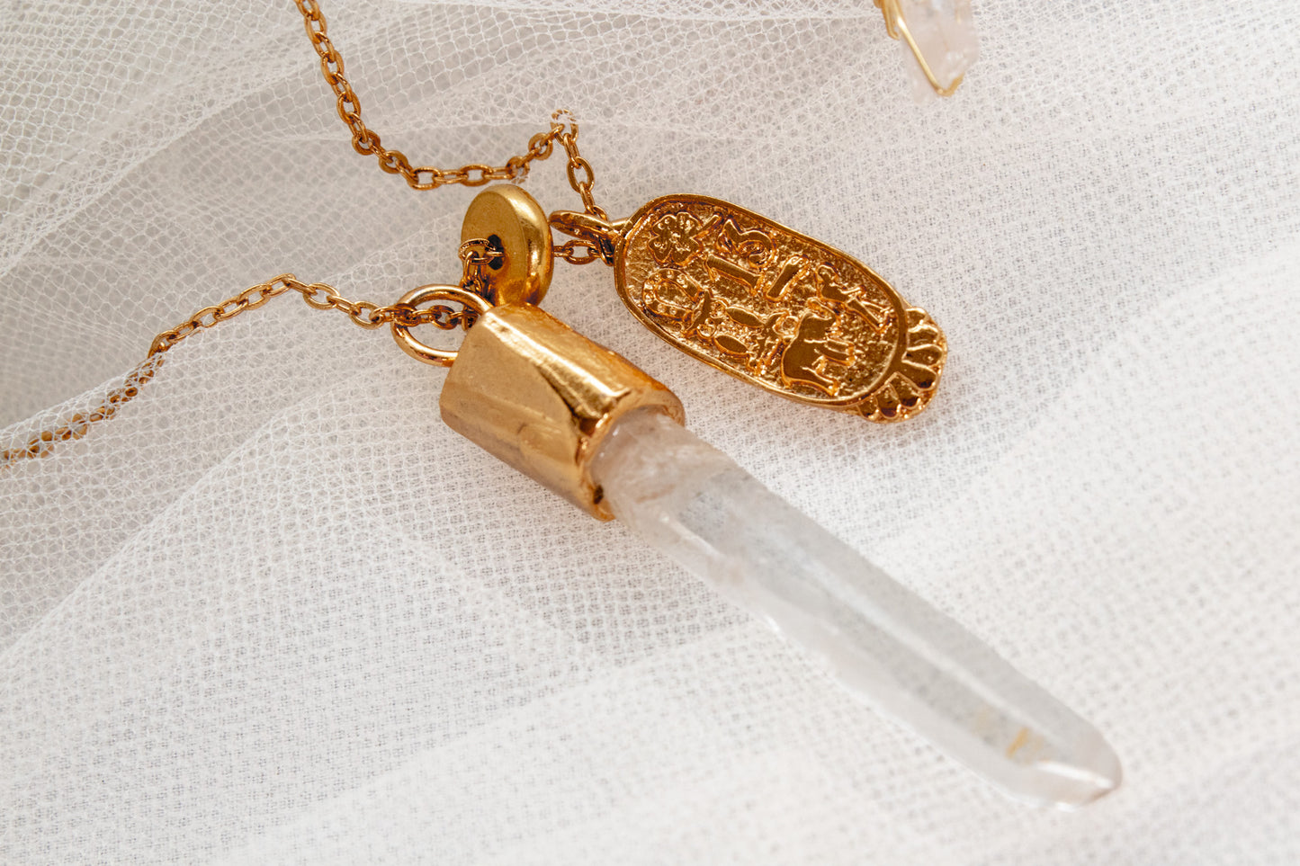 Umbría. Collar con punta de cuarzo blanco y dije oval con símbolos de buena fortuna